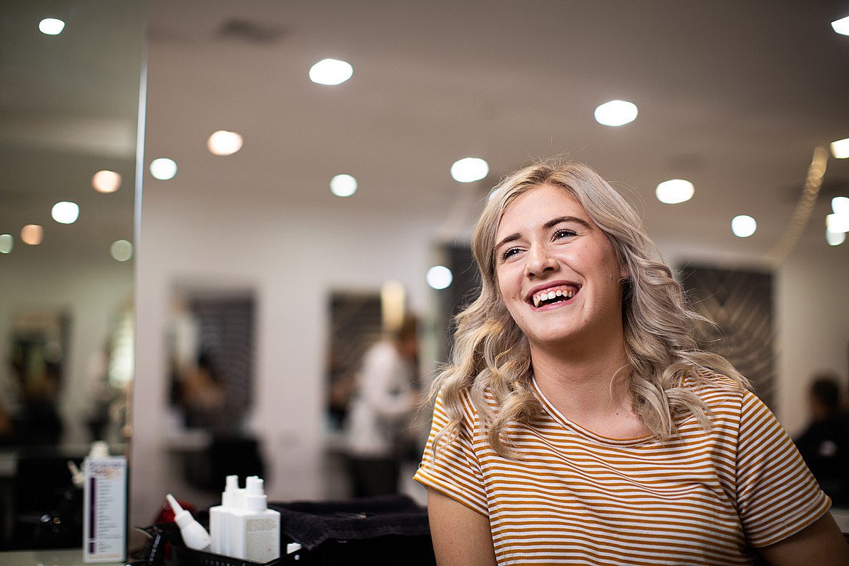 Young female apprentice hairdresser at hair salon in South Australia